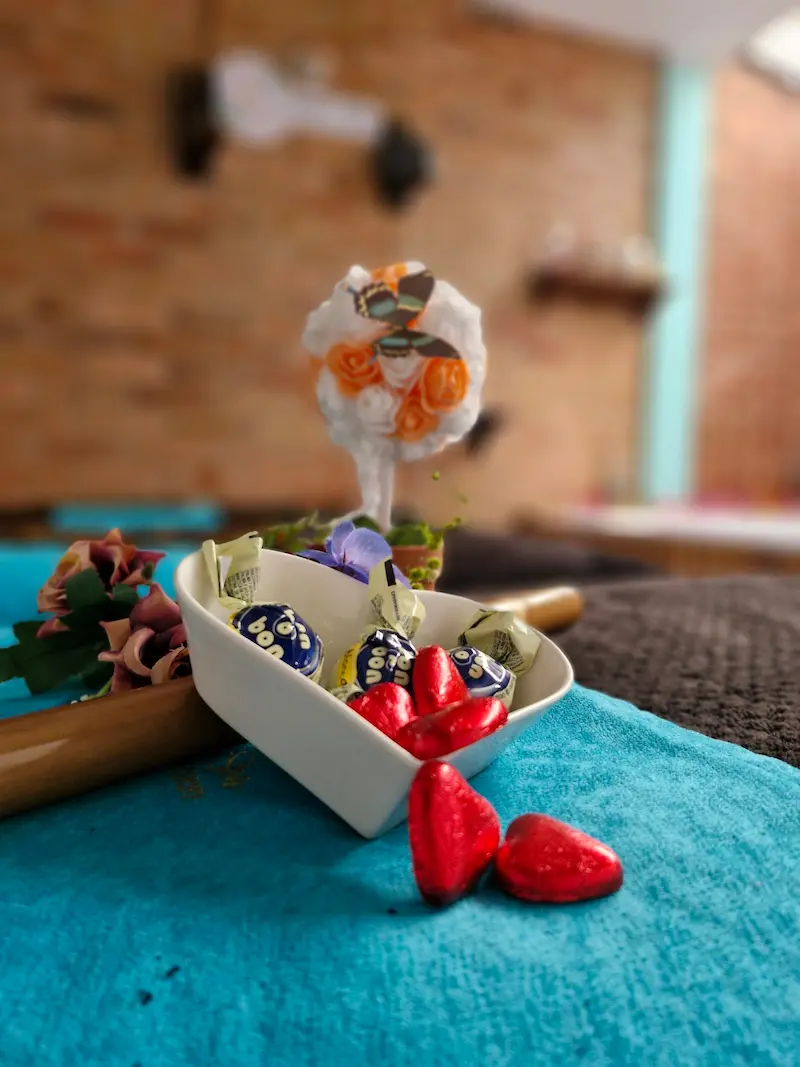 Chocoterapia de Tribbu Spa: bowl en forma de corazón con bombones y corazones de chocolate acompañado de flores
