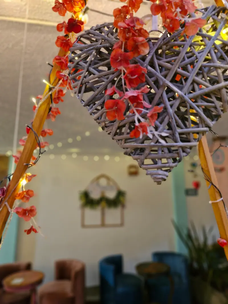 Corazón de mimbre con flores rojas y luces en Tribbu Spa