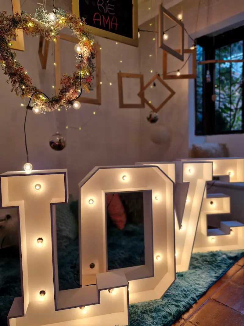 Letras LOVE iluminadas junto a un corazón con luces en Tribbu Spa